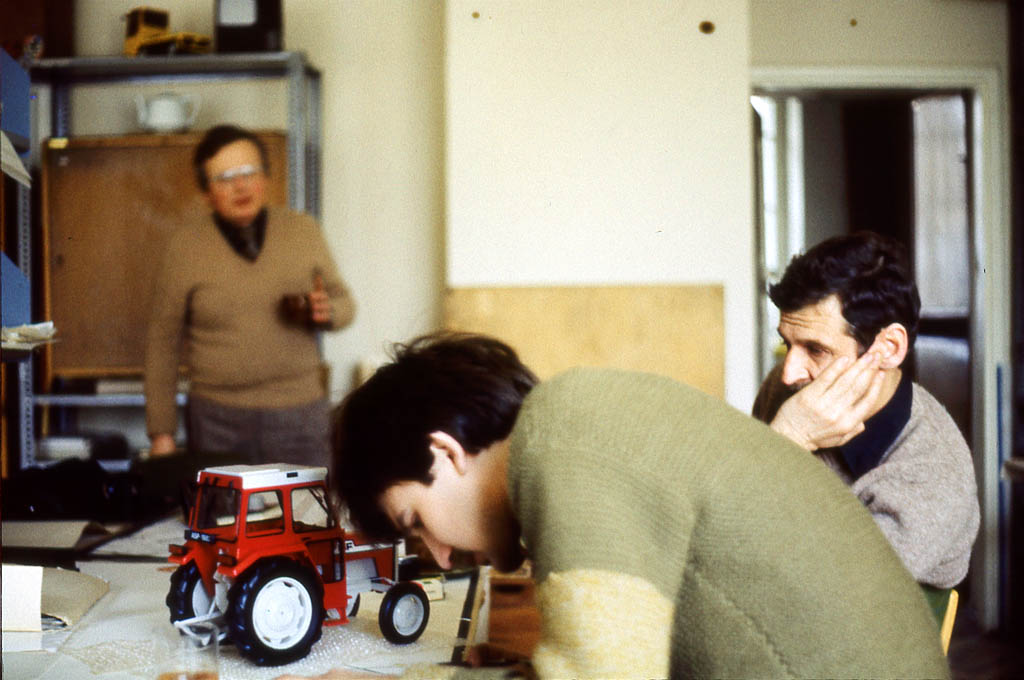 1979. W pracowni na wydziale. Pochylony Jerzy Wojtasik, za nim Bogusław Woźniak, stoi Wojciech Wybieralski. Na stole model ciągnika - praca dyplomowa Pawła Balcerzaka,
fot. ze zbiorów Pawła Balcerzaka, autor nieznany