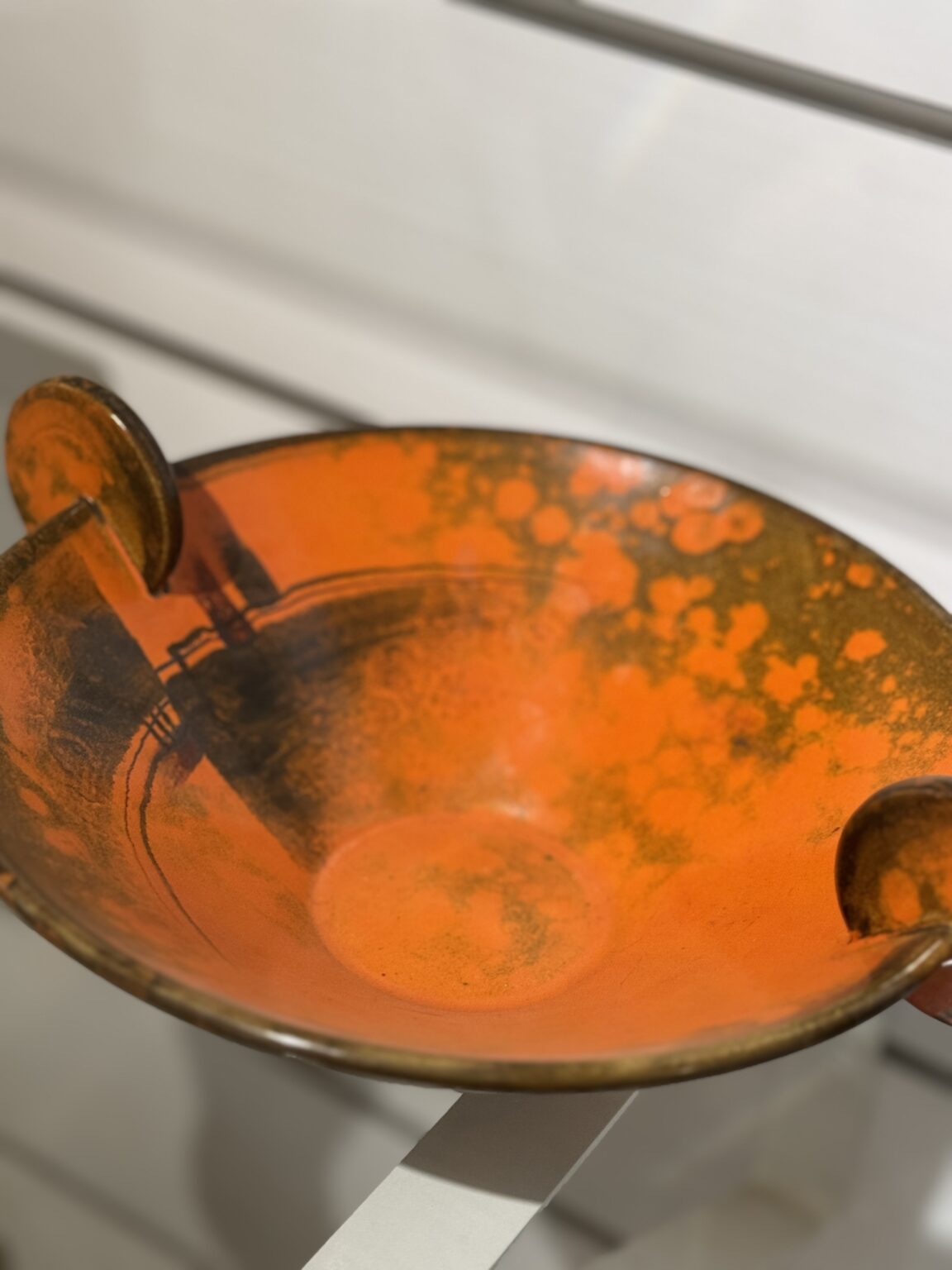 Intensywnie pomarańczowa owocarka z dwojgiem okrągłych uchwytów.